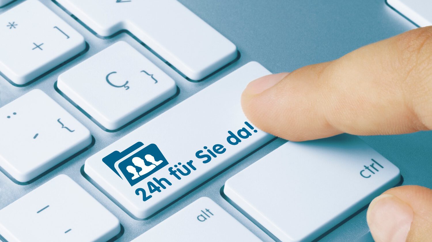 Eine Nahaufnahme einer Computertastatur, auf der ein Finger die Taste "24h für Sie da!" drückt.